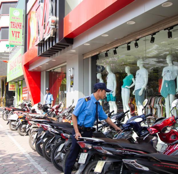 Nhân viên bảo vệ chào đón và hỗ trợ dắt xe cho khách